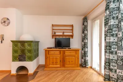 a room with a tv on a wooden cabinet with a tvicterotentotentotent at Casa Cielo Azzurro in Moena