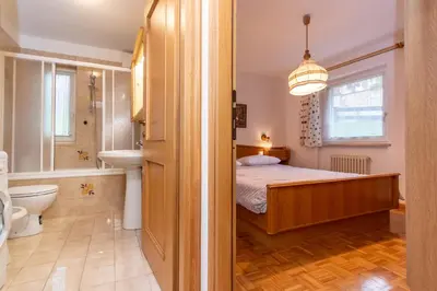 a bedroom with a bed and a bathroom with a sink at Casa Cielo Azzurro in Moena