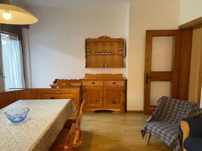 a room with a table and a cabinet and a table and chairs at Mansarda Mulaz in Falcade