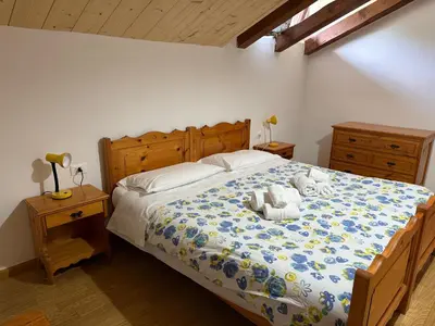 a bedroom with a bed with a teddy bear on it at Mansarda Mulaz in Falcade