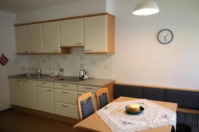 a kitchen with a table and a clock on the wall at Residence Ben Ste in Ortisei