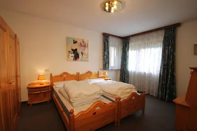 a bedroom with a wooden bed and a window at Residence Ben Ste in Ortisei