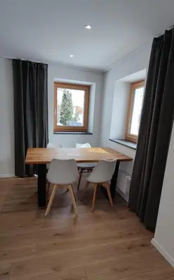 a dining room with a wooden table and two chairs at Alp-Hof Apartments in Stanghe