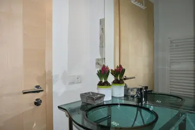 a bathroom with a glass sink with flowers on it at Alp-Hof Apartments in Stanghe