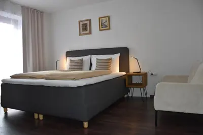 a bedroom with a large bed with white walls at Alp-Hof Apartments in Stanghe