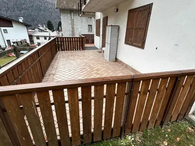 a wooden fence on a balcony of a house at Sole e Neve -Sun & Snow in Forno di Zoldo