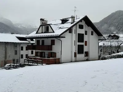 a white house with snow on the ground at Sole e Neve -Sun & Snow in Forno di Zoldo