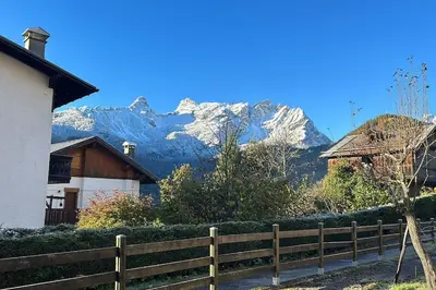 a wooden fence in front of a mountain at Sole e Neve -Sun & Snow in Forno di Zoldo