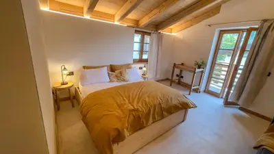 a bedroom with a large bed in a room with windows at Agriturismo Mirtilla in Trento