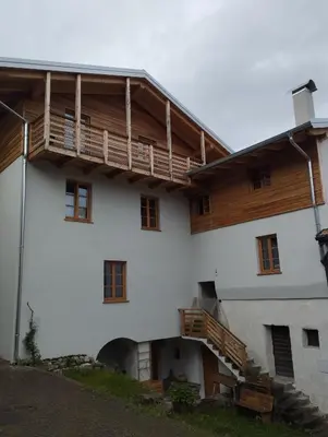 a large white building with wooden balconies on it at Agriturismo Mirtilla in Trento