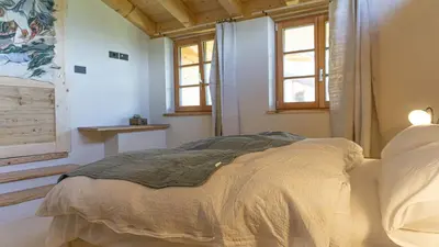 a bedroom with a bed in a room with windows at Agriturismo Mirtilla in Trento