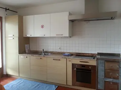 a kitchen with white cabinets and a sink at Alping Apartments in Brunico