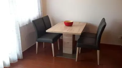 a wooden table with two chairs and a bowl on it at Alping Apartments in Brunico