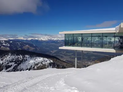 a building on top of a snow covered mountain at Alping Apartments in Brunico