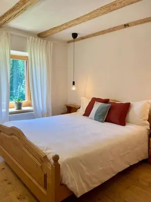 a bedroom with a large white bed with red pillows at Stella Alpina - Romantic getaway in Falcade