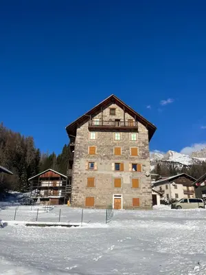 a large building in the middle of a snow covered field at Stella Alpina - Romantic getaway in Falcade