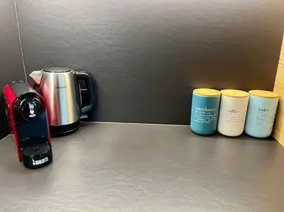 three coffee cups sitting on a counter next to a coffeemaker at Stella Alpina - Romantic getaway in Falcade