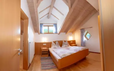 a small bedroom with a bed in a attic at Apartment Getzenbergerhof in Chienes