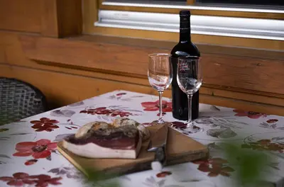 a table with a bottle of wine and two glasses at Apartment Getzenbergerhof in Chienes