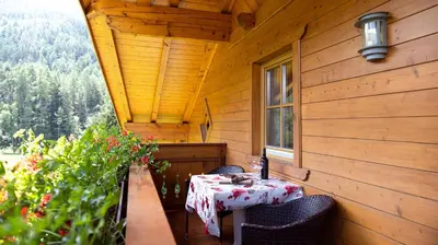 a table on the back porch of a cabin at Apartment Getzenbergerhof in Chienes
