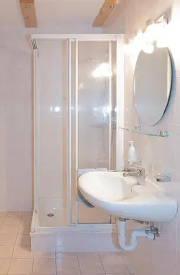 a bathroom with a sink and a shower at Apartment Getzenbergerhof in Chienes