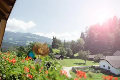 a view of a garden with a house and mountains at Apartment Getzenbergerhof in Chienes