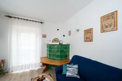a living room with a blue couch and a table at Casa Rosina in Tesero