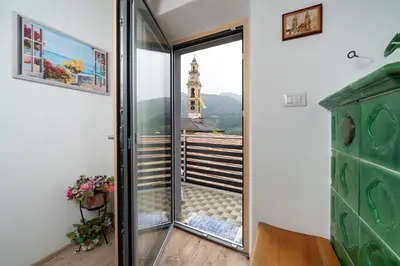 a room with a glass door with a view of a tower at Casa Rosina in Tesero