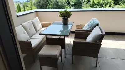 a patio with a couch and a table on a balcony at Janas Bolzano Mountain Apartment in Tesimo