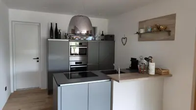 a kitchen with white cabinets and a stove top oven at Janas Bolzano Mountain Apartment in Tesimo