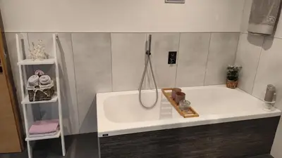 a bathroom with a bath tub with a shower at Janas Bolzano Mountain Apartment in Tesimo