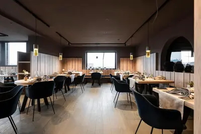 a dining room with tables and chairs and windows at Served Apartements Belvedere in San Genesio Atesino