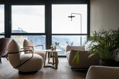 a living room with chairs and a table and windows at Served Apartements Belvedere in San Genesio Atesino