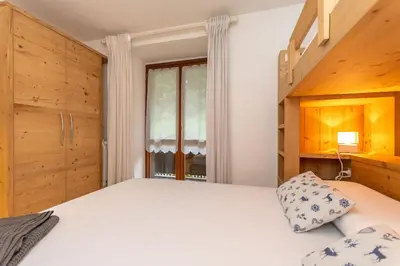 a bedroom with a bed and wooden walls at Casa Nuccia in Moena