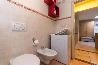 a bathroom with a toilet and a sink at Casa Nuccia in Moena