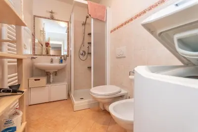 a bathroom with a toilet and a sink and a shower at Casa Nuccia in Moena
