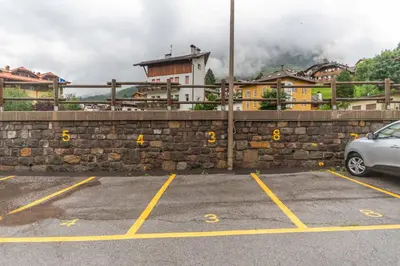 a car parked in a parking lot next to a wall at Casa Nuccia in Moena