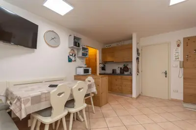 a kitchen and dining room with a table and chairs at Casa Nuccia in Moena