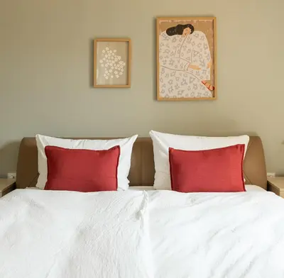 a bedroom with a bed with two red pillows at 240qm Luxus Apartment - Natur & Wandern zw Bozen und Meran in Nalles