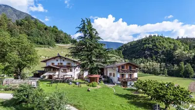 a house in a field with mountains in the background at Punterhof in Varna