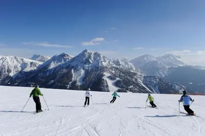 a group of people skiing down a snow covered mountain at Hotel Garni Hochgruber in Brunico