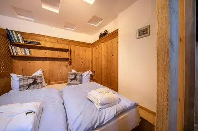 a bedroom with two beds and a book shelf at Cesa dele Angele in Colle Santa Lucia