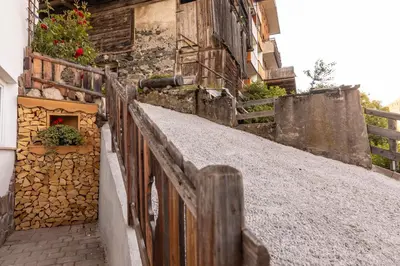 a wooden fence next to a building with flowers at Cesa dele Angele in Colle Santa Lucia