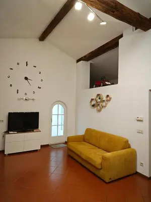 a living room with a couch and a clock on the wall at Appartamento Aquila D'oro in Vipiteno