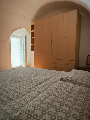 a bedroom with a large bed and wooden cabinets at Appartamento Aquila D'oro in Vipiteno