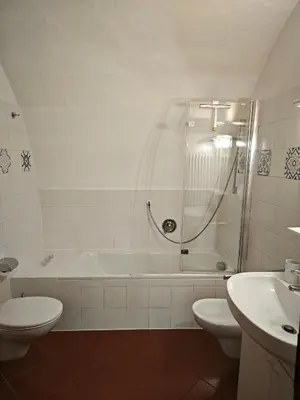 a bathroom with a tub and a toilet and a sink at Appartamento Aquila D'oro in Vipiteno