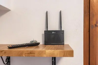 a remote control and a speaker on a wooden shelf at Bilo Cornetto Bianco in Predazzo