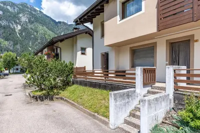 a house with a bench on the side of it at Bilo Cornetto Bianco in Predazzo