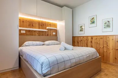 a bedroom with a large bed with wooden walls at Bilo Cornetto Bianco in Predazzo