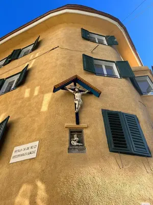 a church with a cross on the side of a building at Alte Schmiede Apartments & Rooms in Bolzano